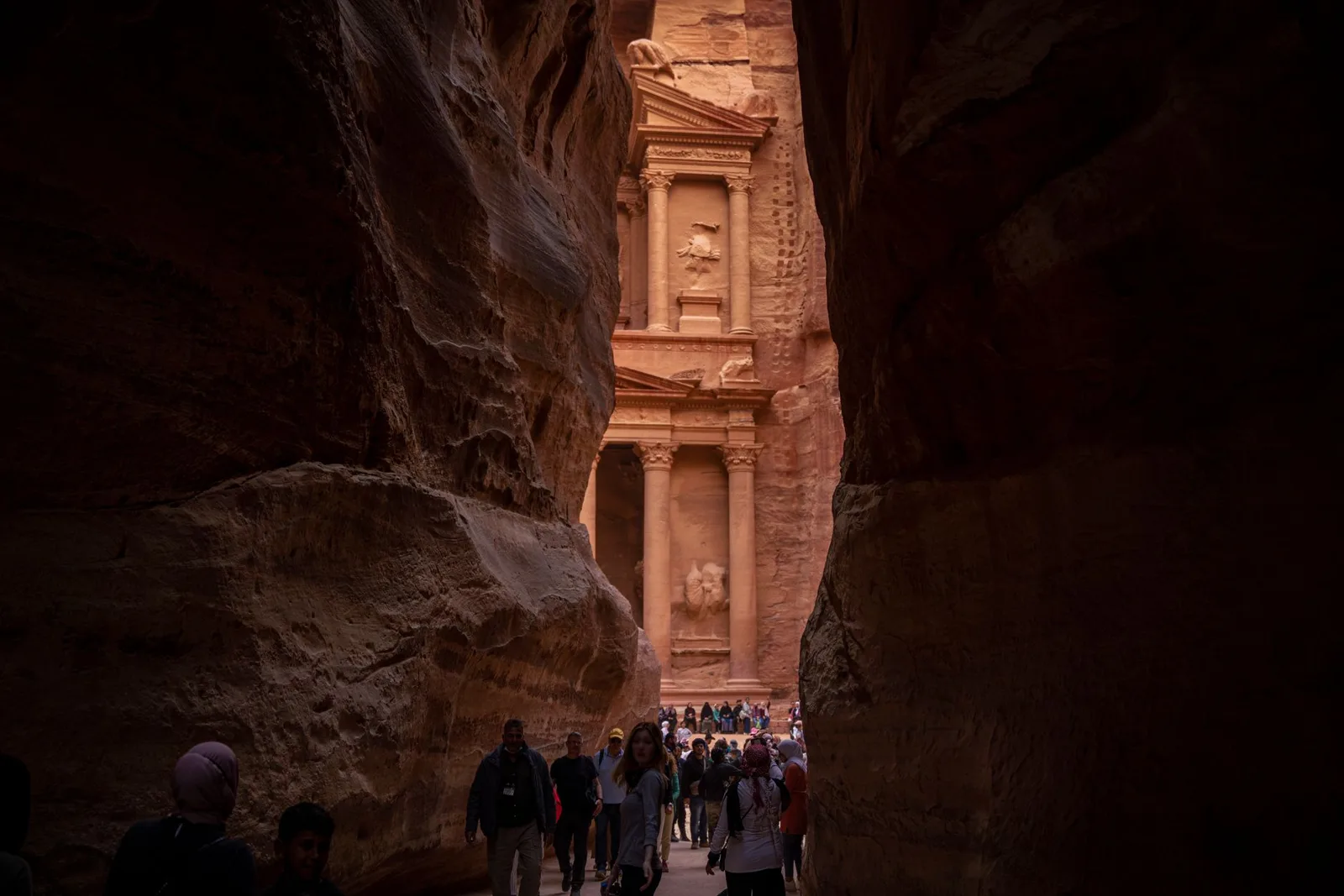 Visitantes caminando por el Siq de Petra hacia el Tesoro