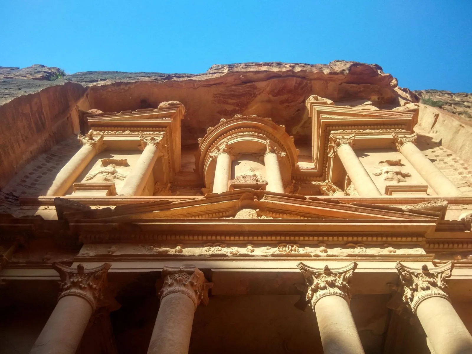 Fachada del Tesoro de Petra vista desde abajo, con columnas y relieves tallados en la roca