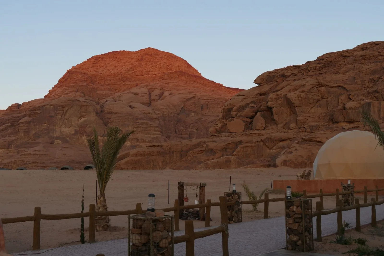 Campamento de cúpulas junto a una montaña rojiza de Wadi Rum al atardecer